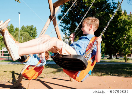 Kids swinging on swings 69799385