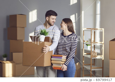 Young couple family with boxes to move in a new house room. 69799417