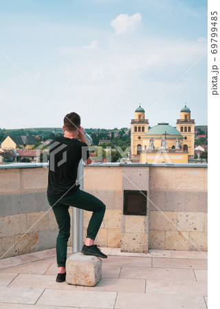 Tourist young man watching the city Eger through a telescope 69799485
