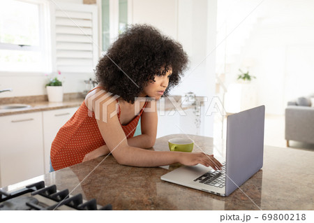 Woman using laptop in the kitchen 69800218