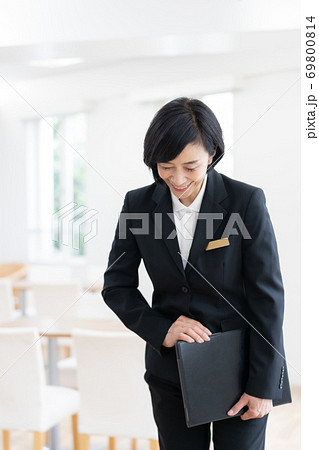 施設の案内をするスーツ姿のミドル女性の写真素材