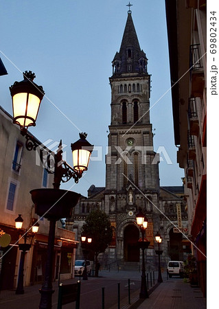 小さな街ルルドに立つ教会とおしゃれな街灯のある夜景の写真素材