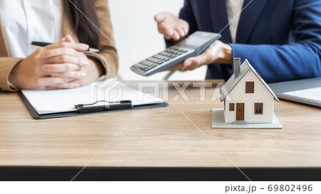 House model with agent and customer discussing for contract to buy, get insurance or loan estate. House model with agent and customer discussing for contract to buy, get insurance or loan estate. 69802496