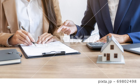 House model with agent and customer discussing for contract to buy, get insurance or loan estate. House model with agent and customer discussing for contract to buy, get insurance or loan estate. 69802498