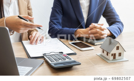House model with agent and customer discussing for contract to buy, get insurance or loan estate. House model with agent and customer discussing for contract to buy, get insurance or loan estate. 69802507