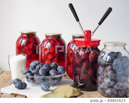 The concept of canning plum compote in glass jars on a wooden table. Place for your text. Country style. 69802625