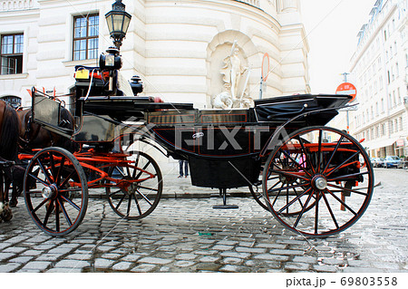 Horse-driven carriage at Hofburg palace, Vienna, Austria Horse-driven carriage at Hofburg palace, Vienna, Austria 69803558