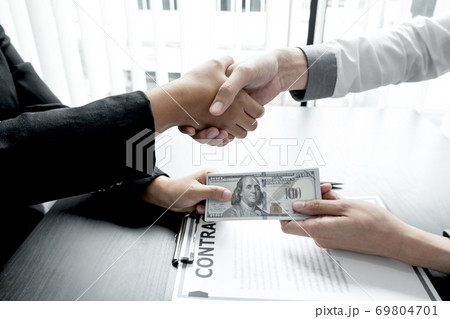 Handshake business and dollar bills sign bribery and corruption contracts Handshake business and dollar bills sign bribery and corruption contracts 69804701