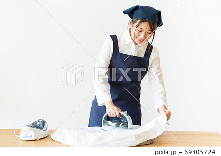 アイロンをかける家事代行の若い女性スタッフ 69805724