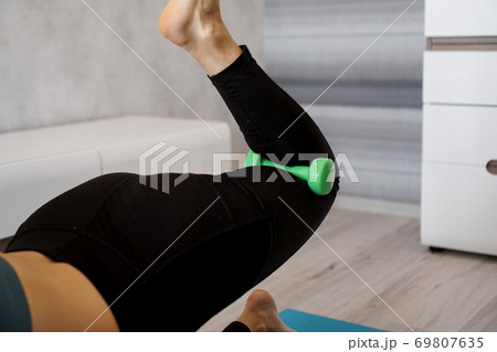 Pretty young trainer doing exercise, using dumbbells. She is training at home 69807635
