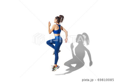 Beautiful young female athlete practicing on white studio background with shadows Beautiful young female athlete practicing on white studio background with shadows 69810085
