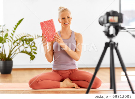 woman with camera streaming for yoga blog at home 69812005