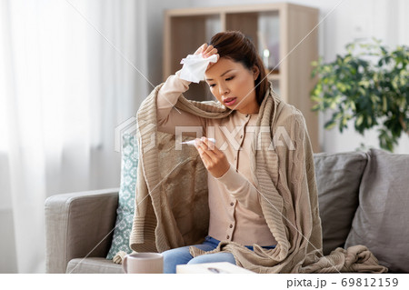 sick woman measuring temperature by thermometer sick woman measuring temperature by thermometer 69812159