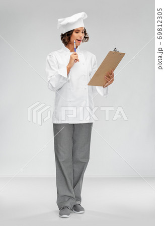 smiling female chef in toque with clipboard smiling female chef in toque with clipboard 69812305