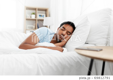 indian man sleeping in bed at home indian man sleeping in bed at home 69812791