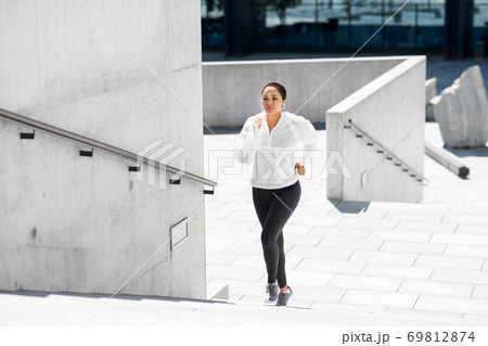 african american woman running upstairs outdoors 69812874