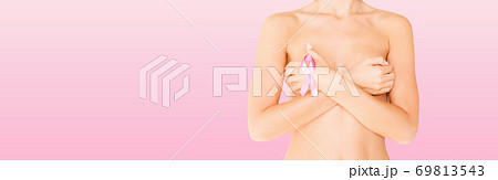 young woman checking breast for signs of cancer young woman checking breast for signs of cancer 69813543