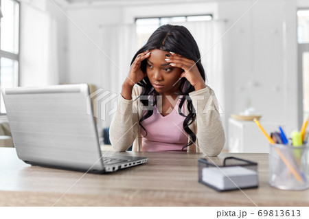 stressed woman with laptop working at home office 69813613