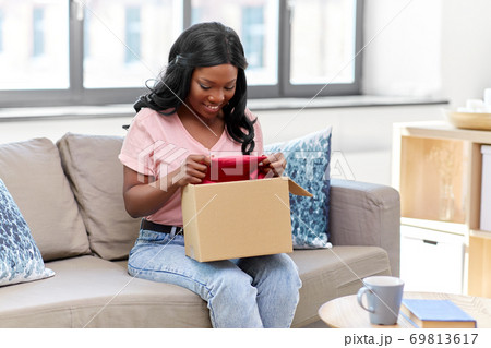 african american woman opening parcel box at home 69813617