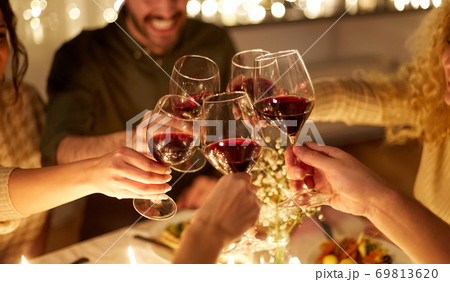 happy friends drinking red wine at christmas party 69813620
