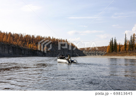 Autumn rafting on a boat with fishing on the Siberian river Autumn rafting on a boat with fishing on the Siberian river 69813645