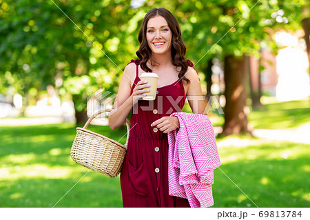 happy woman with picnic basket and coffee at park 69813784