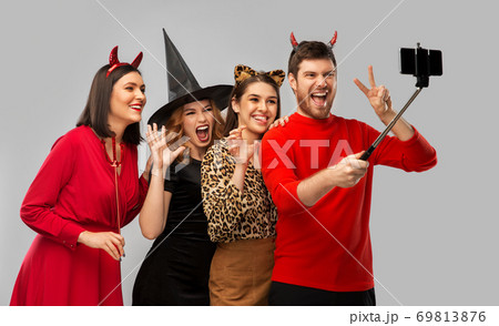 happy friends in halloween costumes taking selfie happy friends in halloween costumes taking selfie 69813876