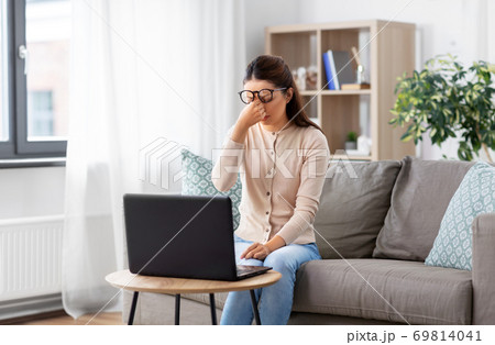 tired woman with laptop working at home office 69814041