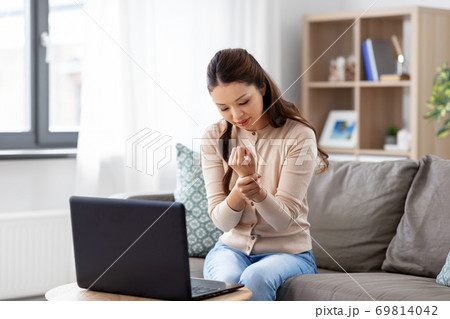 asian woman with laptop having hand ache at home 69814042