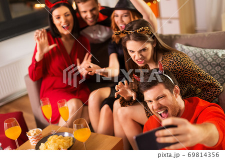 happy friends in halloween costumes taking selfie happy friends in halloween costumes taking selfie 69814356