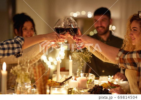 happy friends drinking red wine at christmas party happy friends drinking red wine at christmas party 69814504