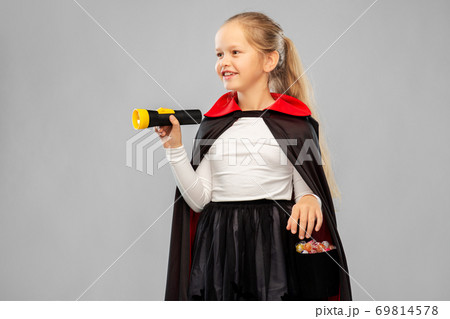 girl in halloween costume of dracula with candies 69814578