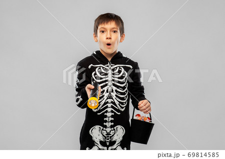 boy in halloween costume with candies and torch 69814585