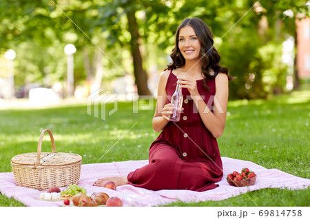 happy woman with picnic basket and drink at park happy woman with picnic basket and drink at park 69814758