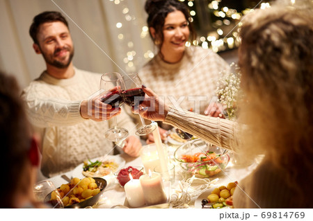 happy friends drinking red wine at christmas party happy friends drinking red wine at christmas party 69814769