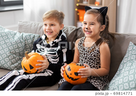 kids in halloween costumes with pumpkins at home kids in halloween costumes with pumpkins at home 69814771