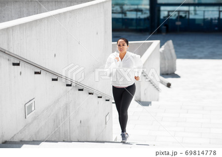 african american woman running upstairs outdoors 69814778