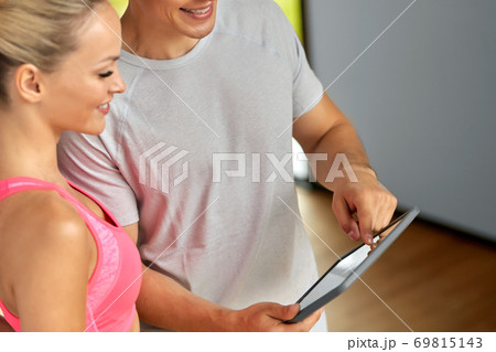 close up of man and woman with tablet pc in gym 69815143