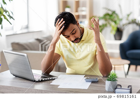 man with calculator and papers working at home 69815161