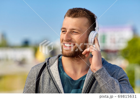 man in headphones listening to music outdoors man in headphones listening to music outdoors 69815631