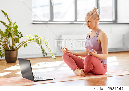 woman with laptop in lotus pose at yoga studio woman with laptop in lotus pose at yoga studio 69815644