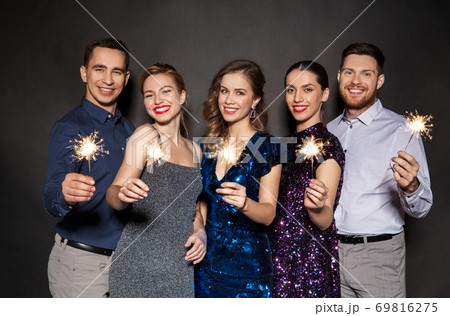 happy friends in party clothes with sparklers happy friends in party clothes with sparklers 69816275