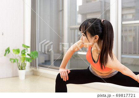 マンション室内で運動する筋トレ女子 ストレッチ ダイエット スポーツ ポニーテールの写真素材