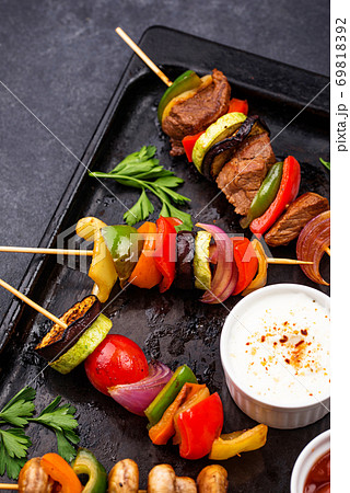 Grilled kebabs with meat, mushrooms and vegetables 69818392