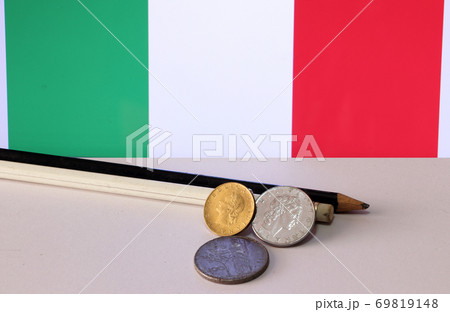 Heap of Italy coins and pencil on white floor with Italia flag background, REPVBBLICA ITALIANA 69819148