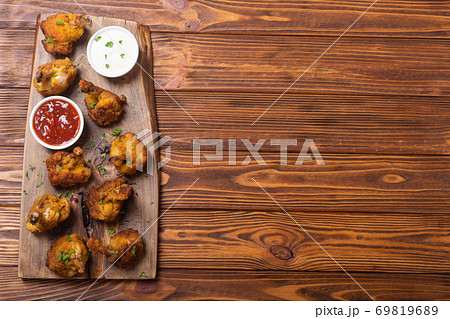Chicken wings nuggets with sauces on wooden background . 69819689