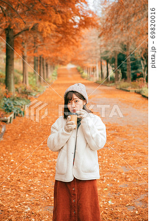 冬の公園でホットドリンクを飲む女性 冬の公園でホットドリンクを飲む女性 69820016