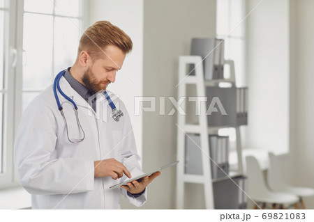 Male doctor pediatrician standing in the white office of the hospital. 69821083
