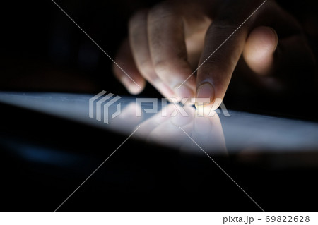 Close up of hacker hand stealing data from digital tablet Close up of hacker hand stealing data from digital tablet 69822628