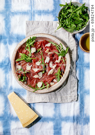 Beef carpaccio, cheese and arugula Beef carpaccio, cheese and arugula 69824784